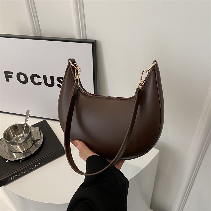 Sac à main marron aux lignes arrondies et aux attaches dorées